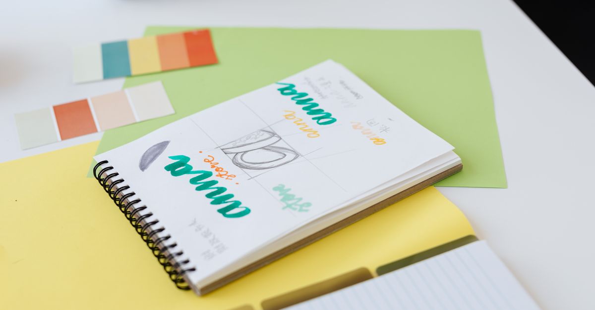 Illustrator's desk with sketches, color swatches, and printed cover drafts