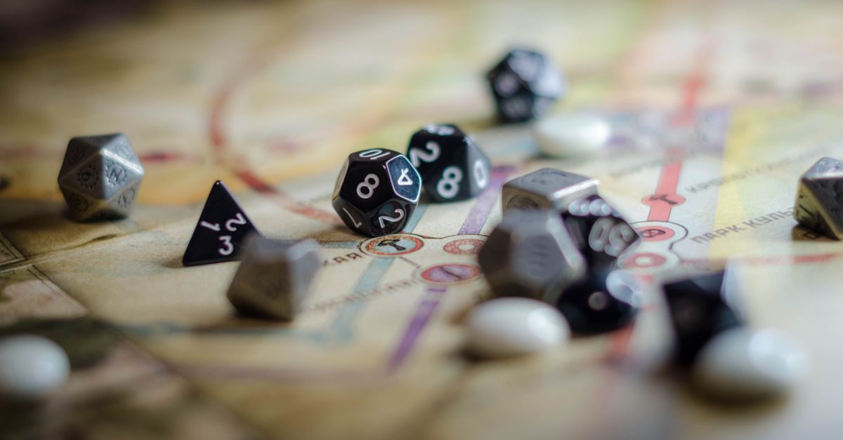 Tabletop game session with dice, character sheets, and hand-drawn maps on a table